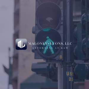 Maloney-Lyons, LLC Attorneys at Law logo over a pedestrian crossing signal, symbolizing legal services from a Biloxi Pedestrian Accident Lawyer