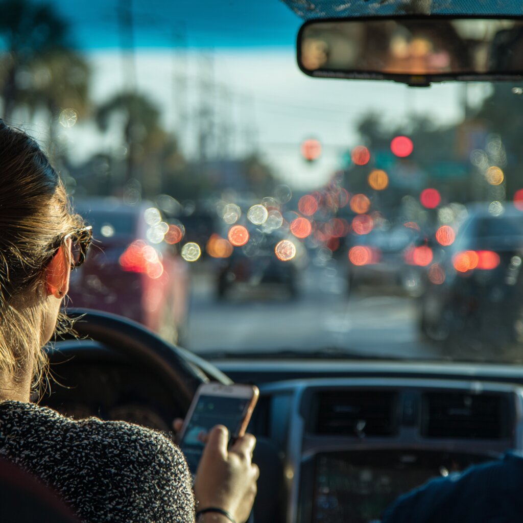 View from inside of a car of a woman texting and driving in heavy traffic in Biloxi, Mississippi