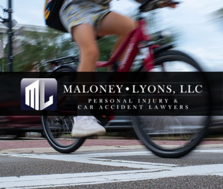 Teenager on an e-bike crossing the road with traffic behind in Biloxi, Mississippi